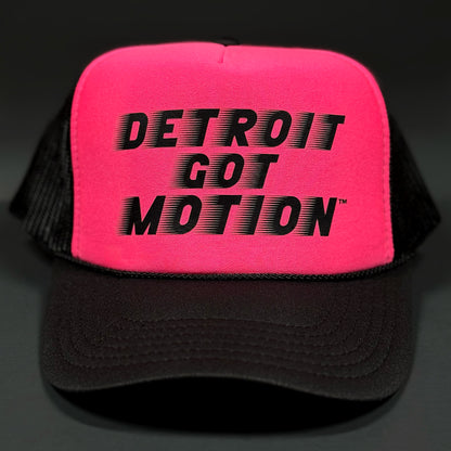 Pink cap with 'Detroit Got Motion' text on a dark background.